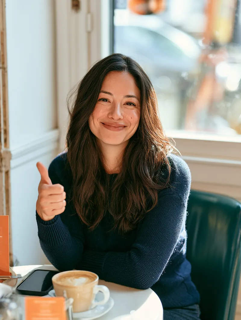 American customer giving a cheerful thumbs-up at a cafe table
